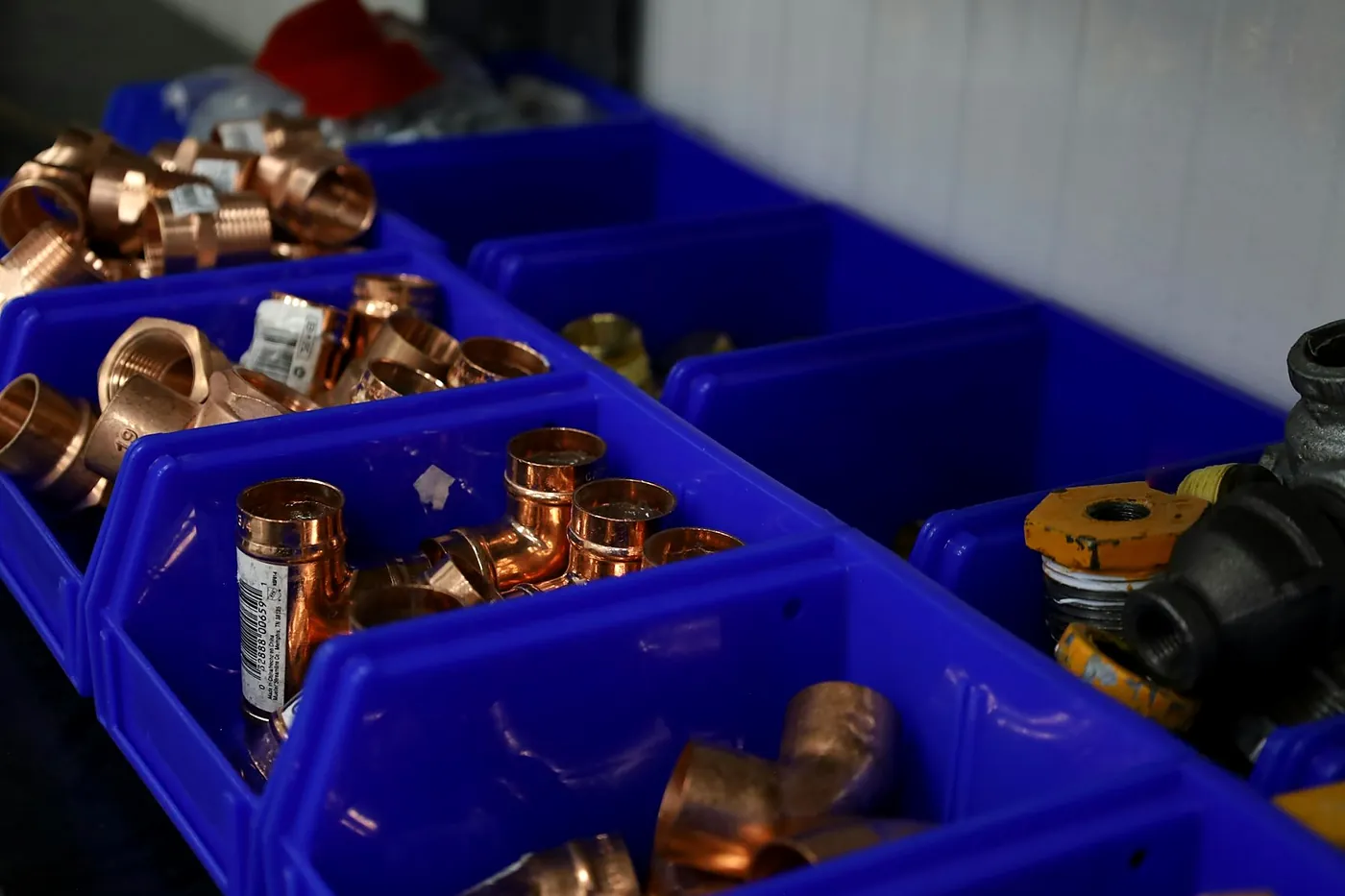 Blue plastic bins in a van full of copper pipe fittings