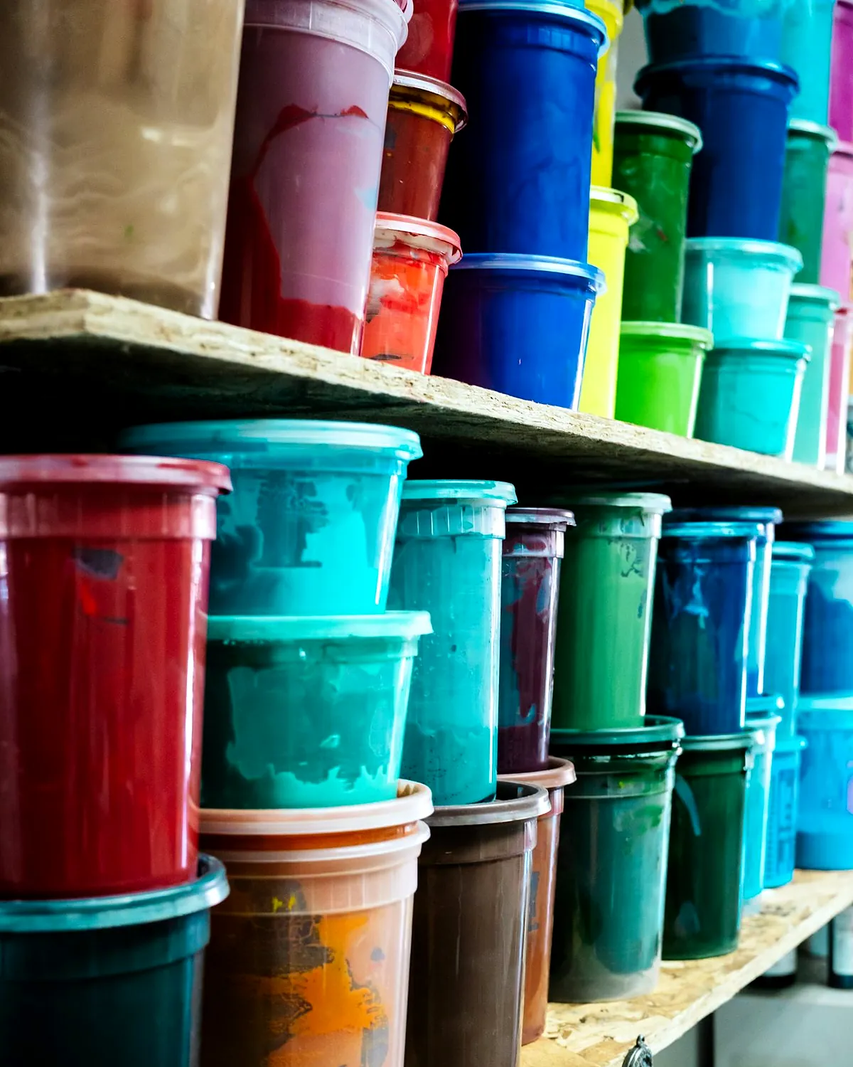 Shelves of ink tubs in blue, green, red and teal.