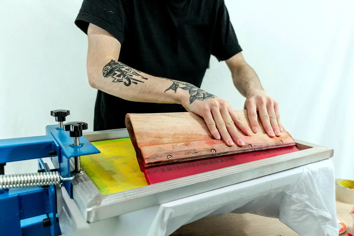 Pulling a colour across the screen with a wooden squeegee.