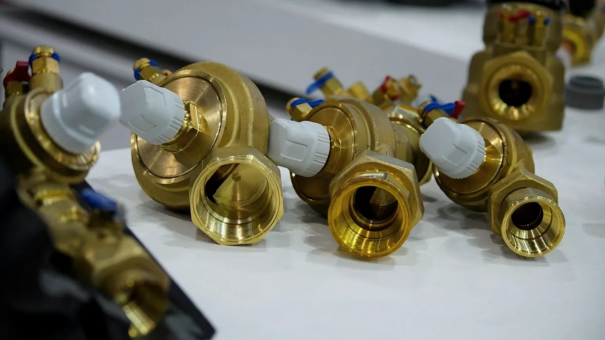 Brass valves with white caps lined up on a counter