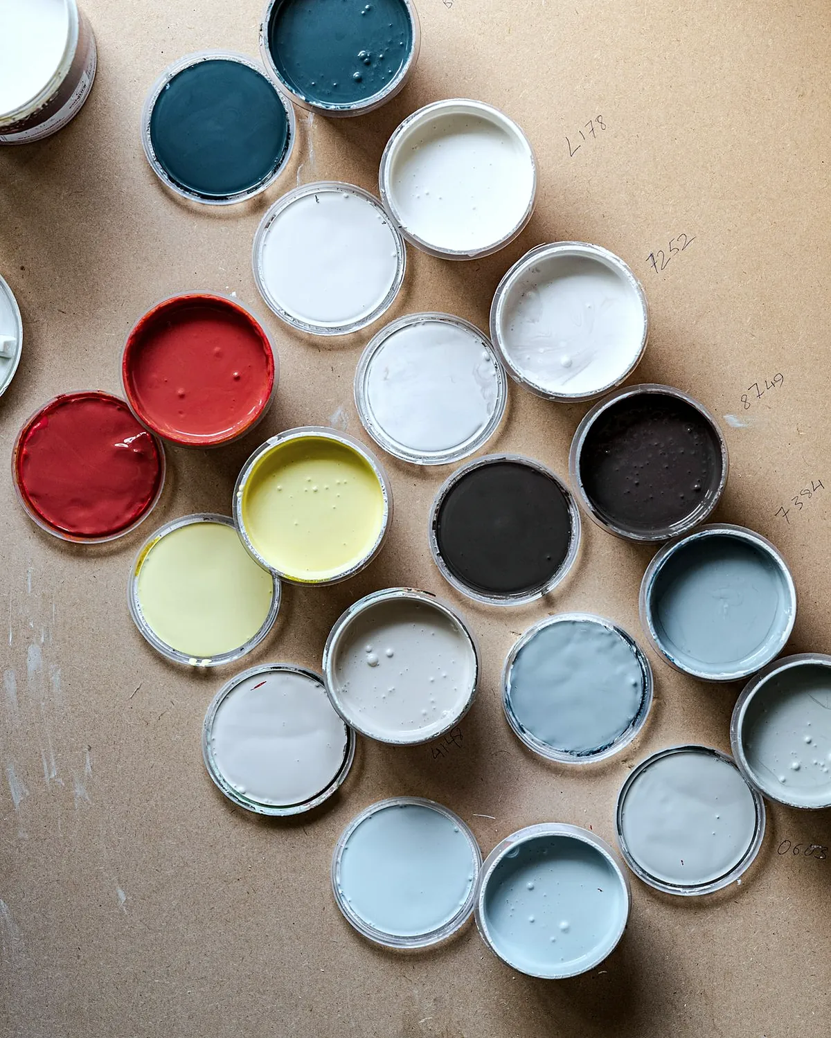 Open paint tins in many colours seen from above