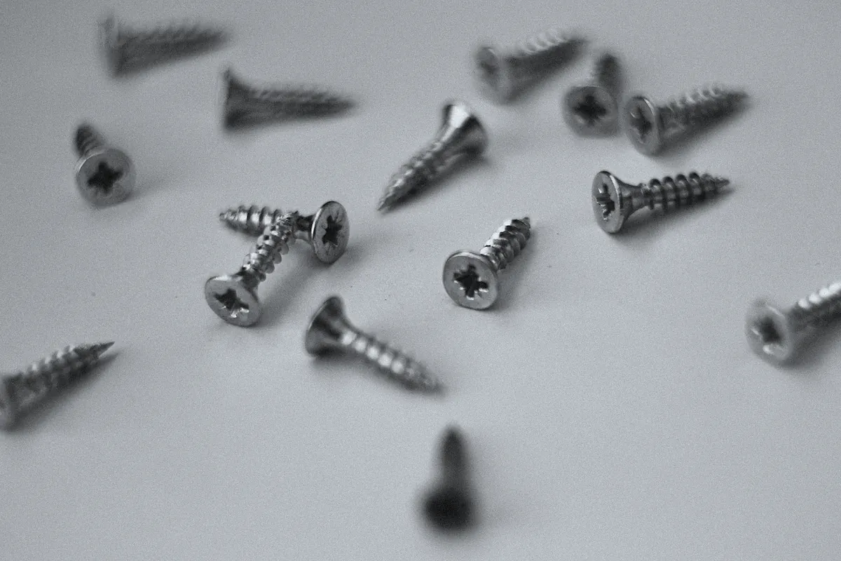 Countersunk screws scattered on a grey surface