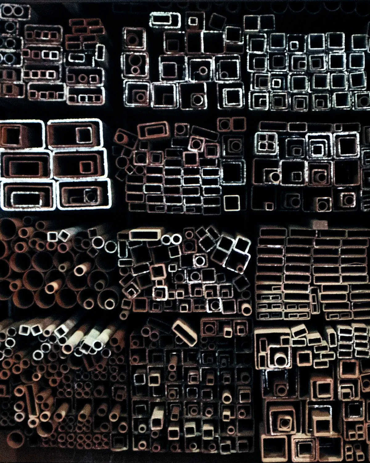 Ends of square and round steel tube stacked in racks