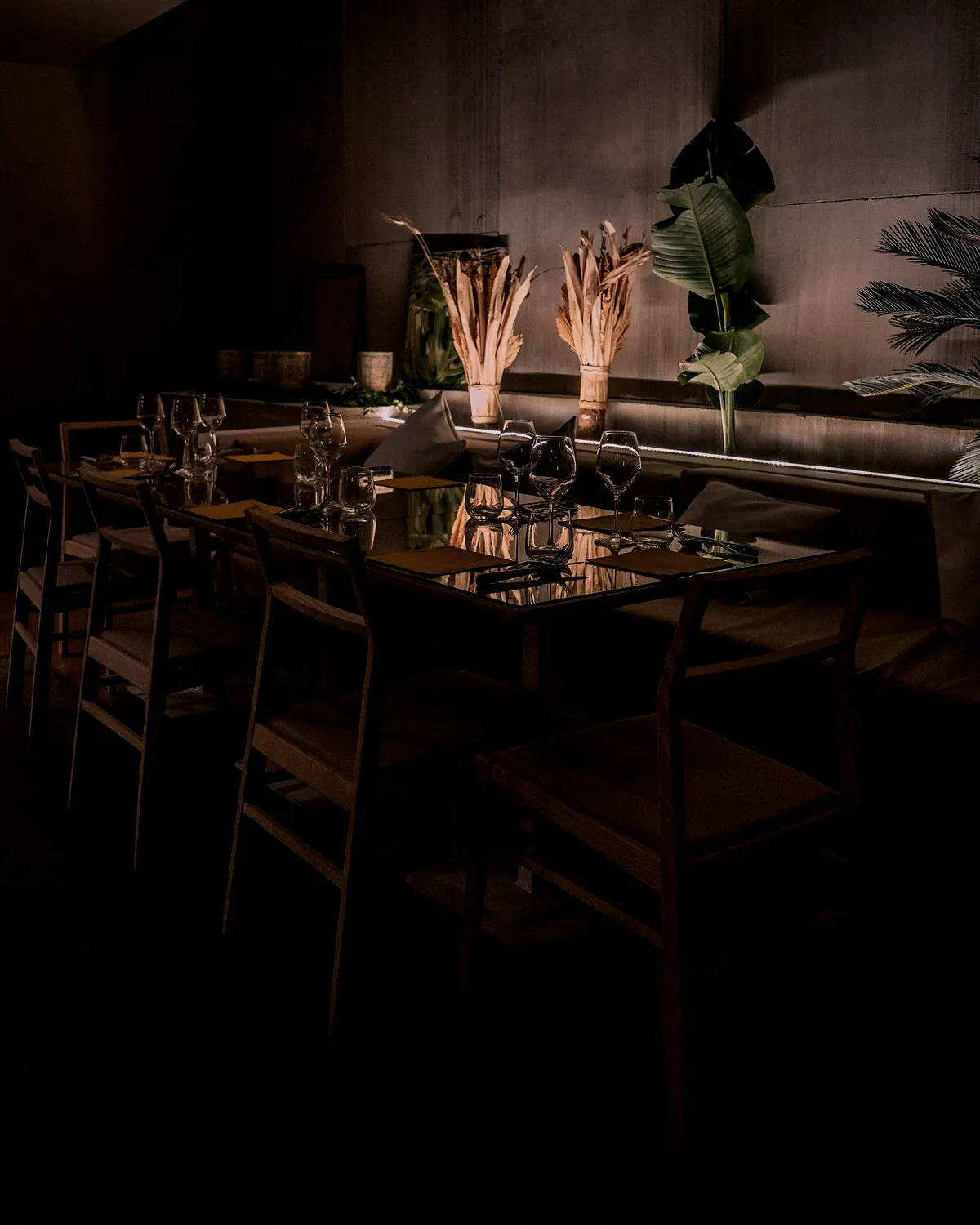 A long dining table set for a group in a dark room