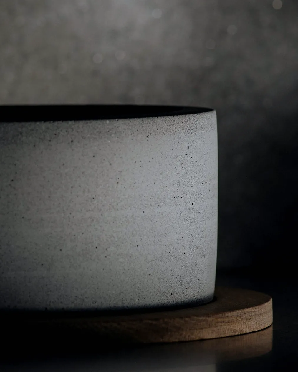 A straight sided tumbler in speckled white, lit from the left