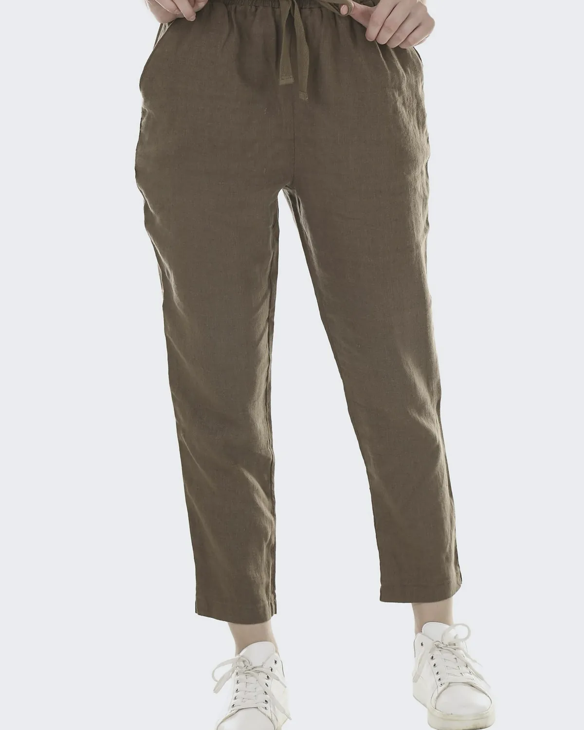Olive linen trousers with a gathered waist and a fabric tie, narrowing to the ankle, in a white studio