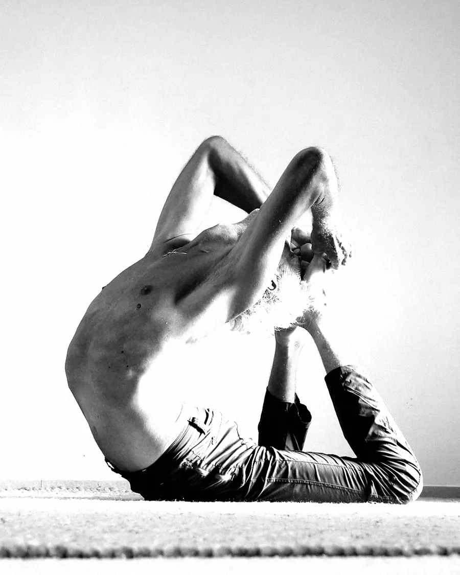 A man in a deep back bend holding his foot behind his head