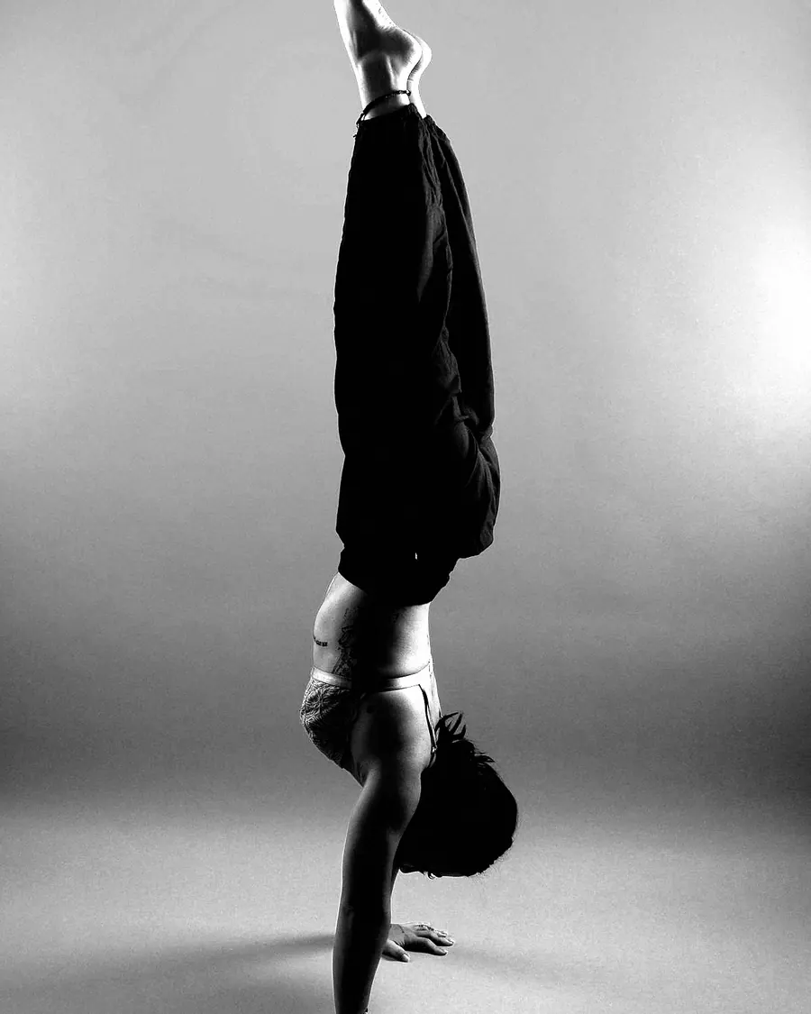 A woman holding a handstand with her legs split