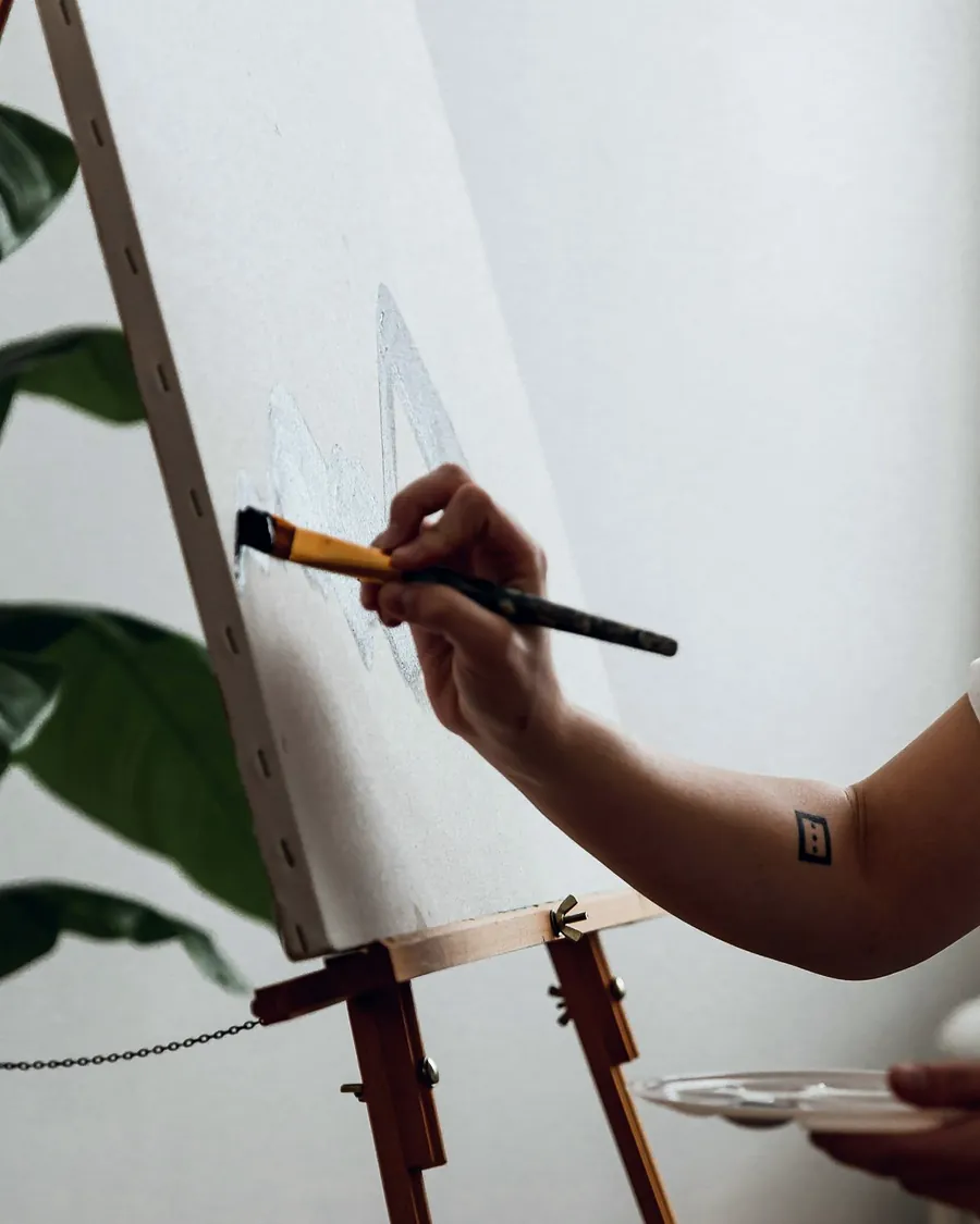 A hand painting on a white canvas on a wooden easel