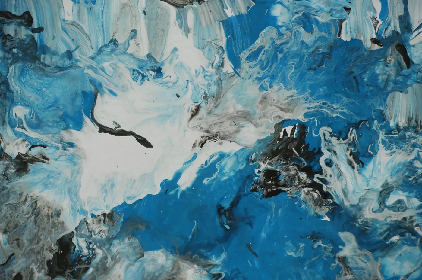 Blue and white paint swirled together, with a few black marks across the middle