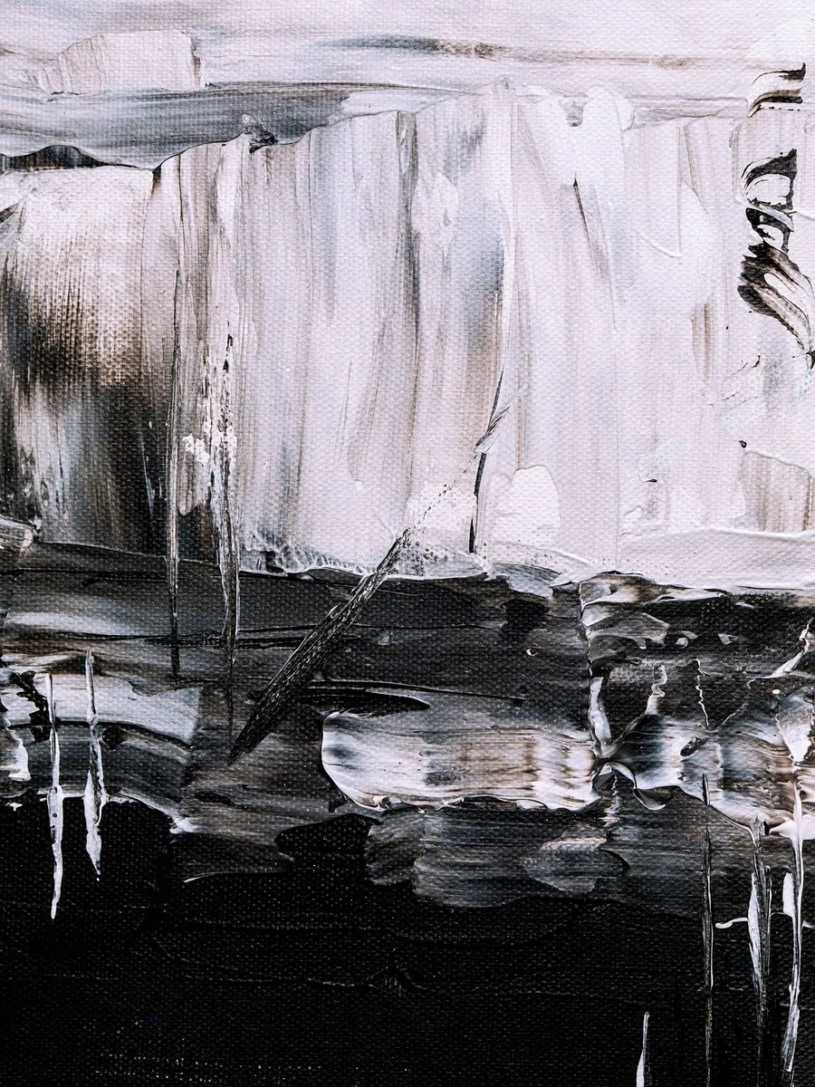 White paint dragged over a black lower half, with grey drips running down