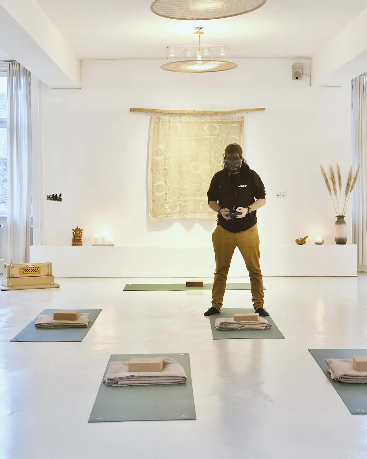 A white hall with mats and blocks laid out in rows and a man standing at the front