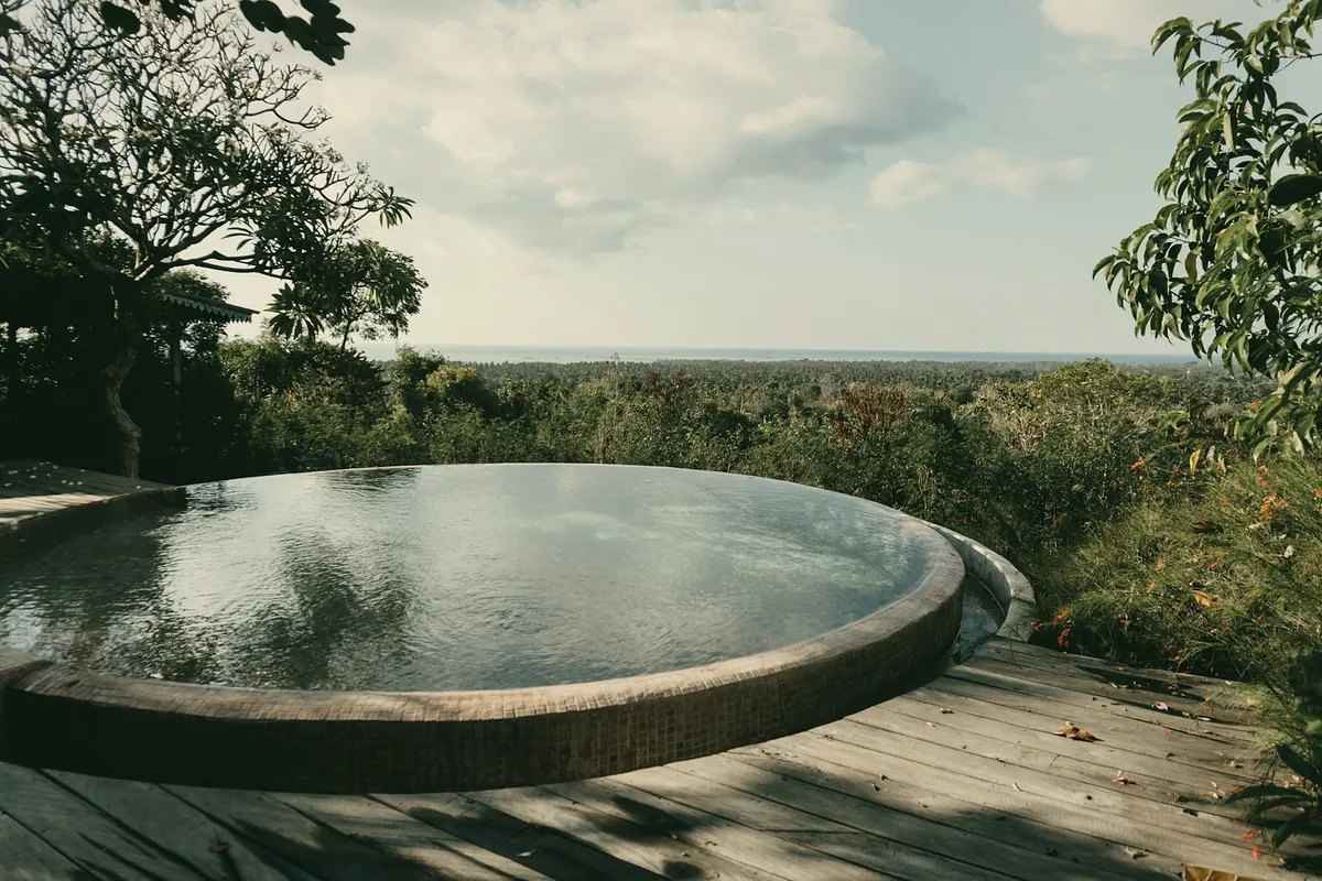A round pool on a timber deck looking over trees and fields to the horizon