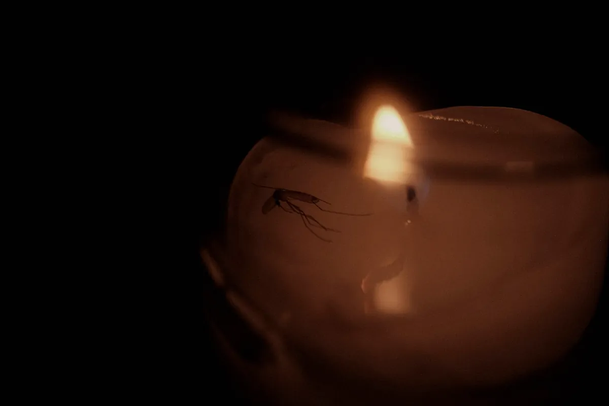 A candle glowing inside a frosted glass in a dark room