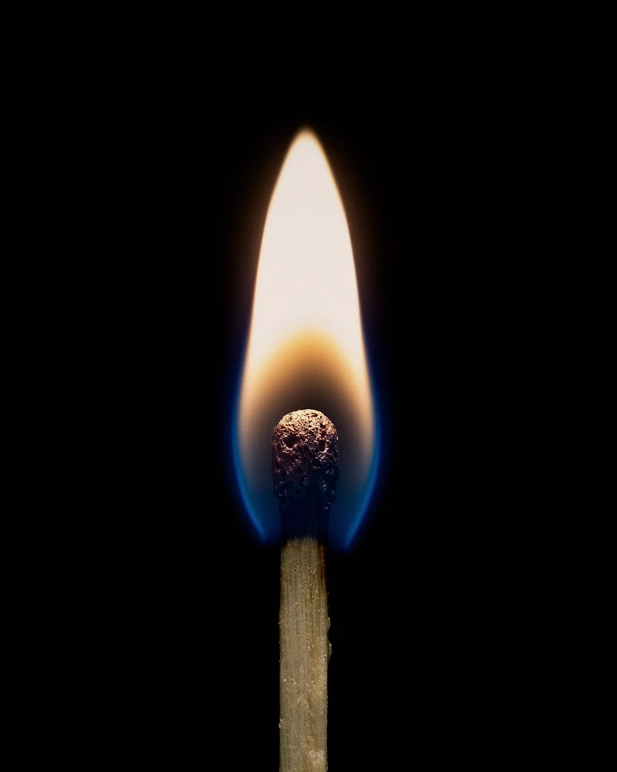 A lit match against a black background