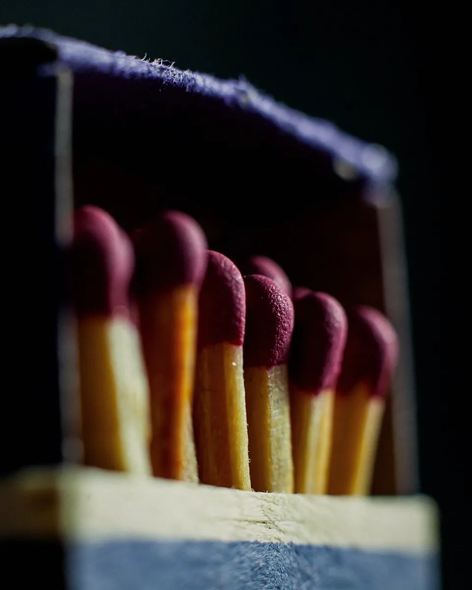 Red tipped matches standing in an open matchbox